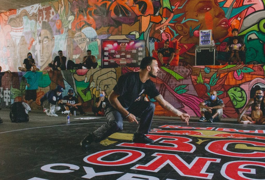 Vibrant street dance captured against colorful graffiti wall, showcasing urban art and culture.