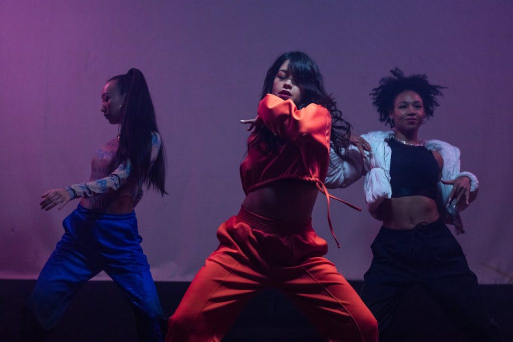 Dynamic trio of female dancers in a powerful hip hop performance on stage.